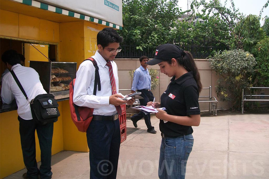 Promoters with visitors at a yellow BlackBerry promotion kiosk