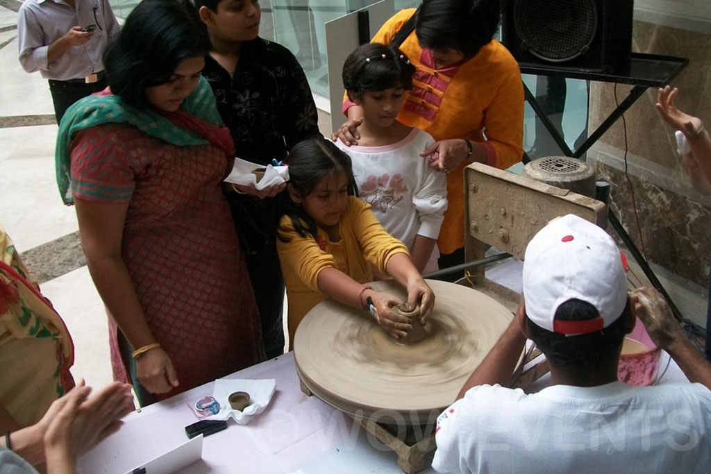 Child trying pottery with help at the carnival
