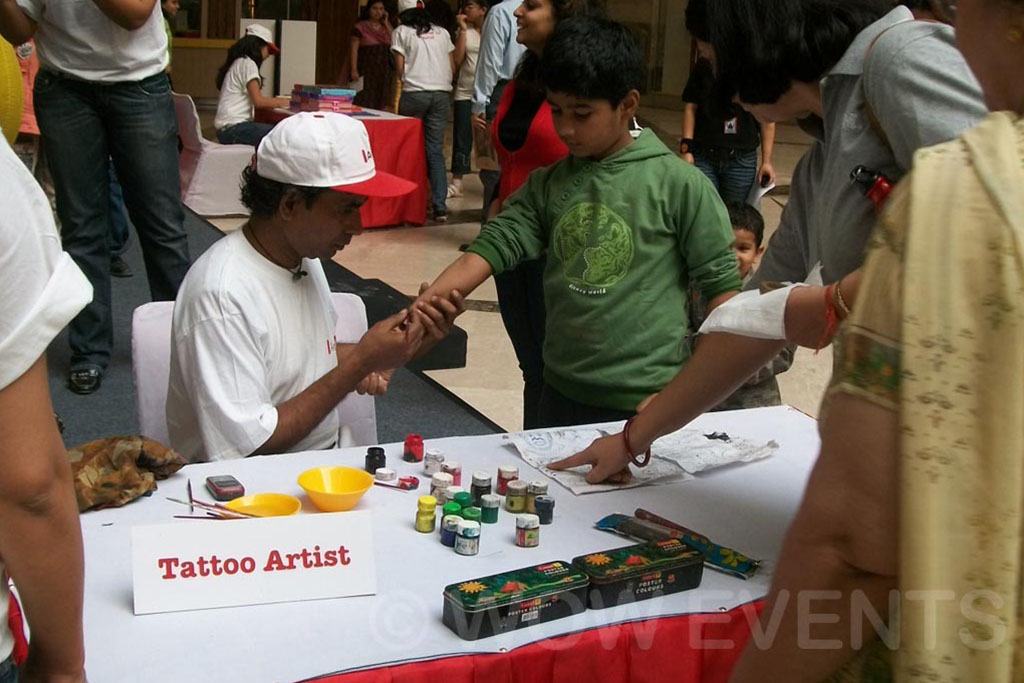 Tattoo artist stall with children at the carnival
