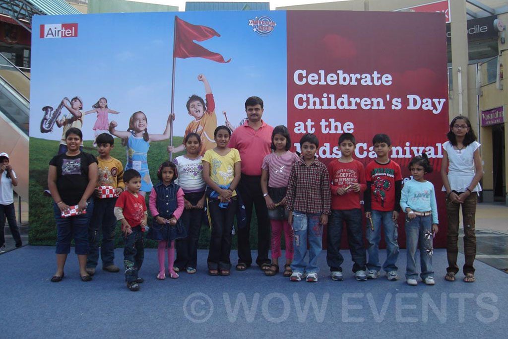 _0003_airtel-childrenday5 Children posing by the Celebrate Children's Day carnival banner