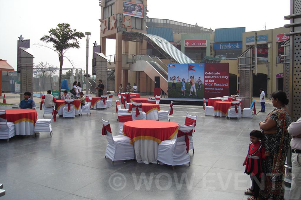 Carnival venue with red tables and a stage