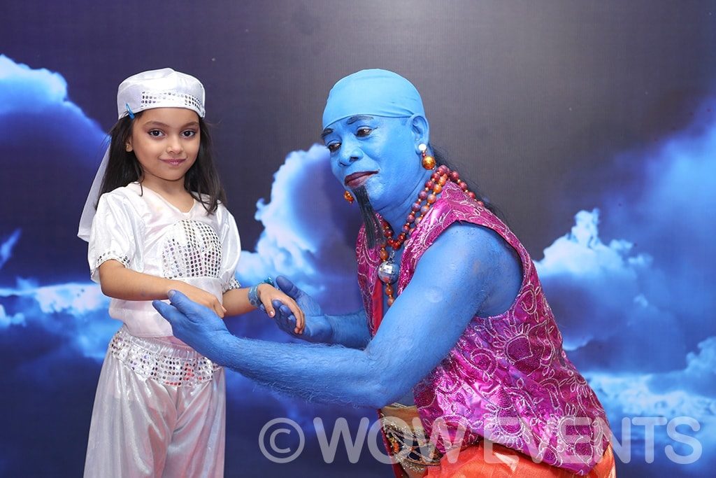 Child posing with a blue genie performer