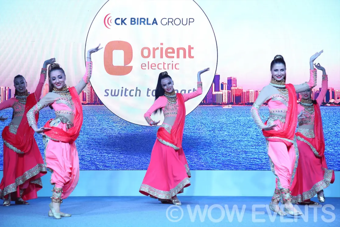 Dancers performing in front of the Orient Electric screen