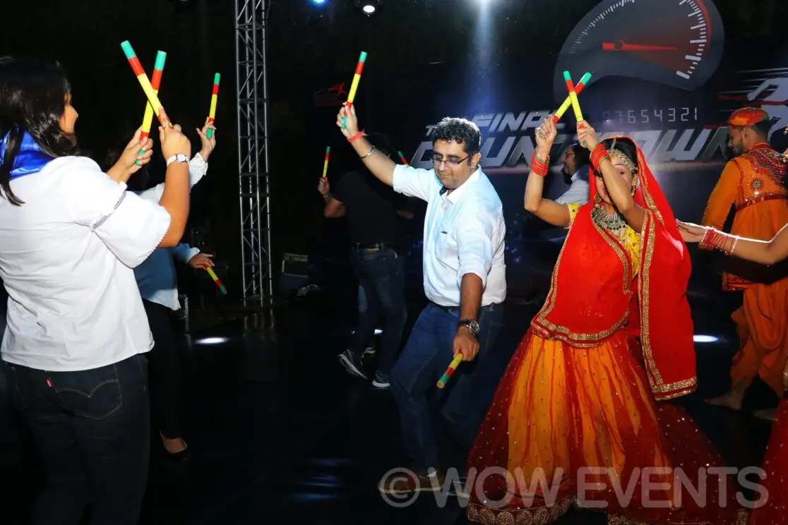 Dancer performing among guests holding glow sticks