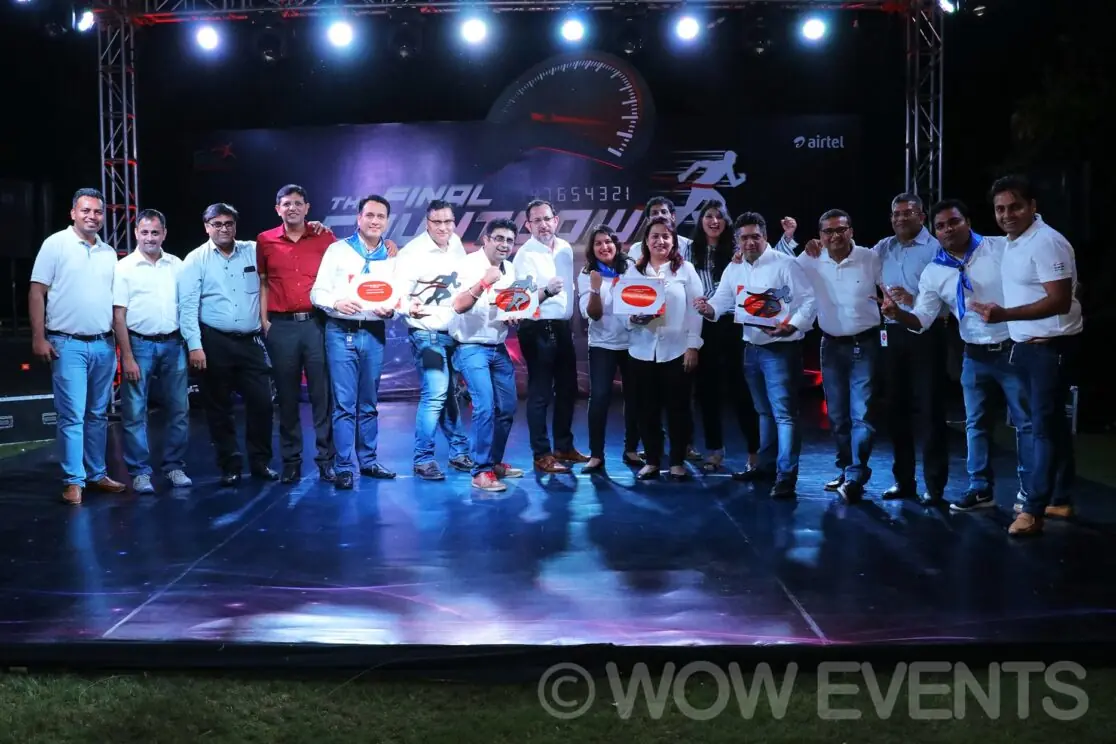 Airtel team in white shirts posing on stage