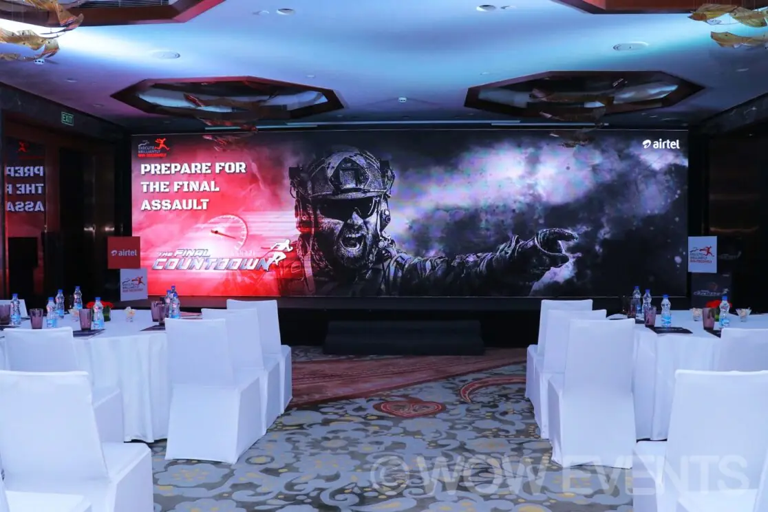 Conference hall with a large stage screen and white tables