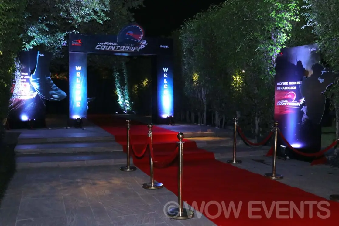 Red carpet pathway lit with blue lights at night