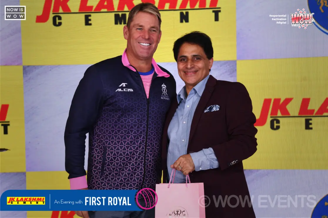 Shane Warne posing with a guest at the JK Lakshmi Cement backdrop