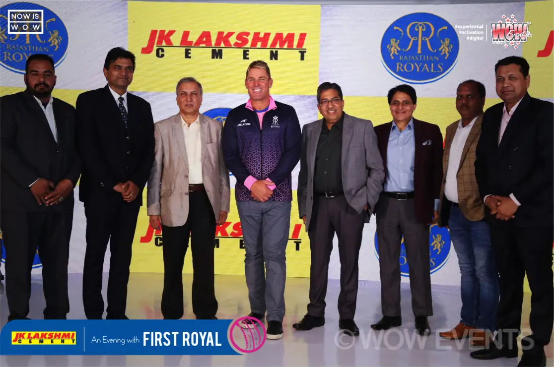 Shane Warne with JK Lakshmi Cement executives in front of the backdrop