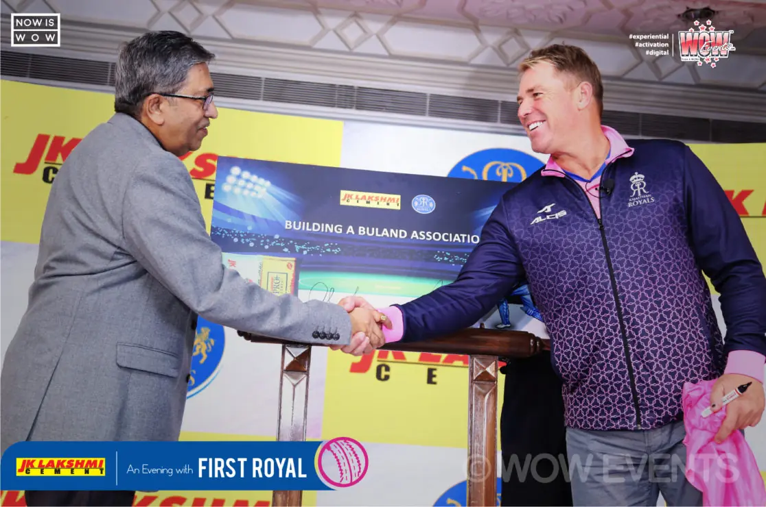 Guest shaking hands with Shane Warne on stage