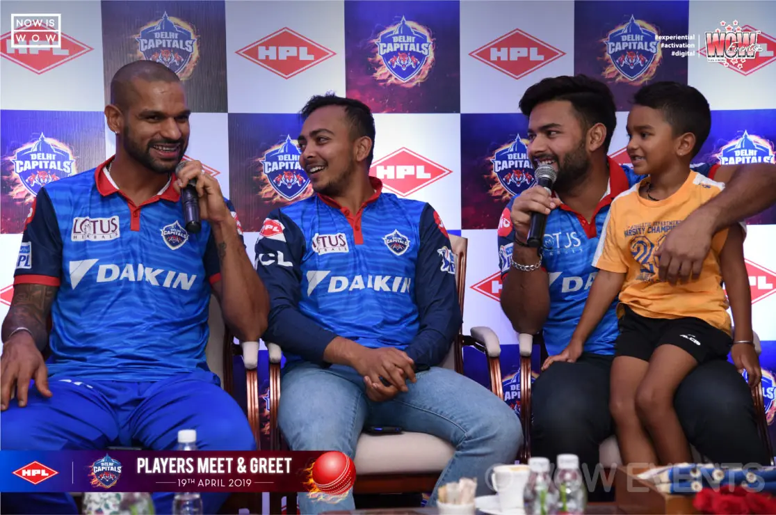 Delhi Capitals players seated on stage