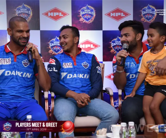 Delhi Capitals players seated on stage