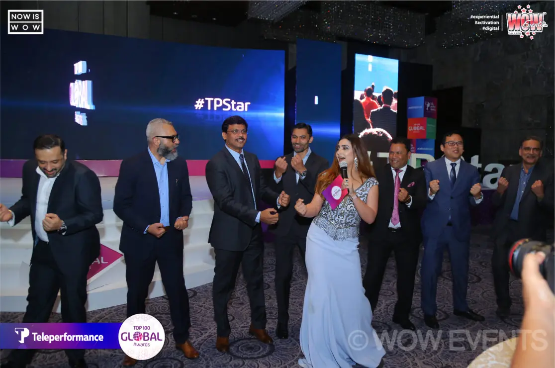 Teleperformance executives celebrating on stage