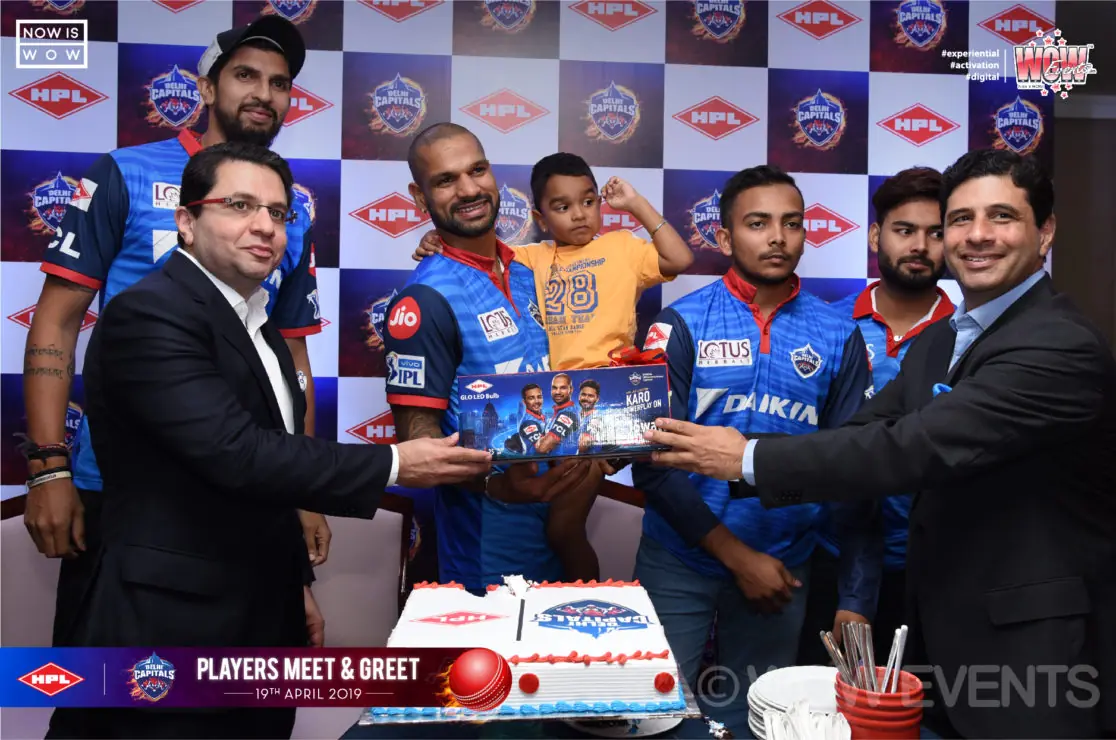 Delhi Capitals players cutting a cake with guests