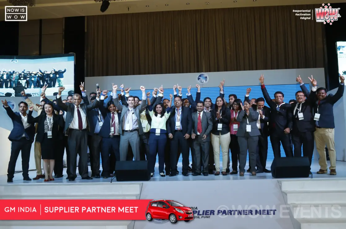 Executive speaking beside a Chevrolet car on stage