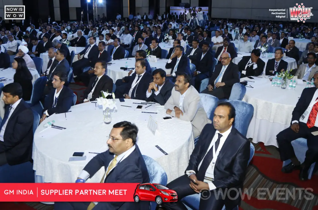Host on stage beside a Chevrolet display