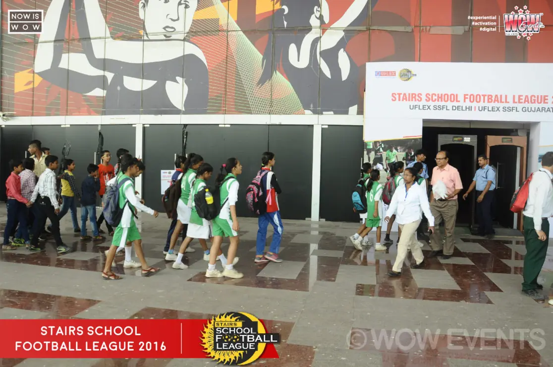 Students walking past the Stairs School Football League backdrop