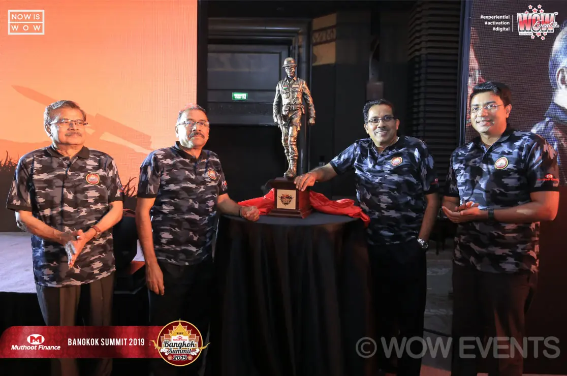 Muthoot Finance team in camouflage shirts on stage