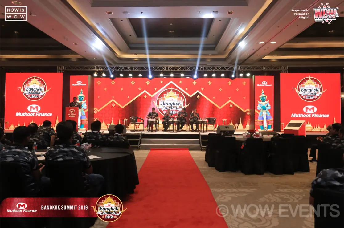 Stage with red screens at the Muthoot Finance summit