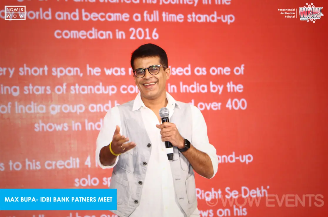 Stand-up comedian performing in front of a bio screen