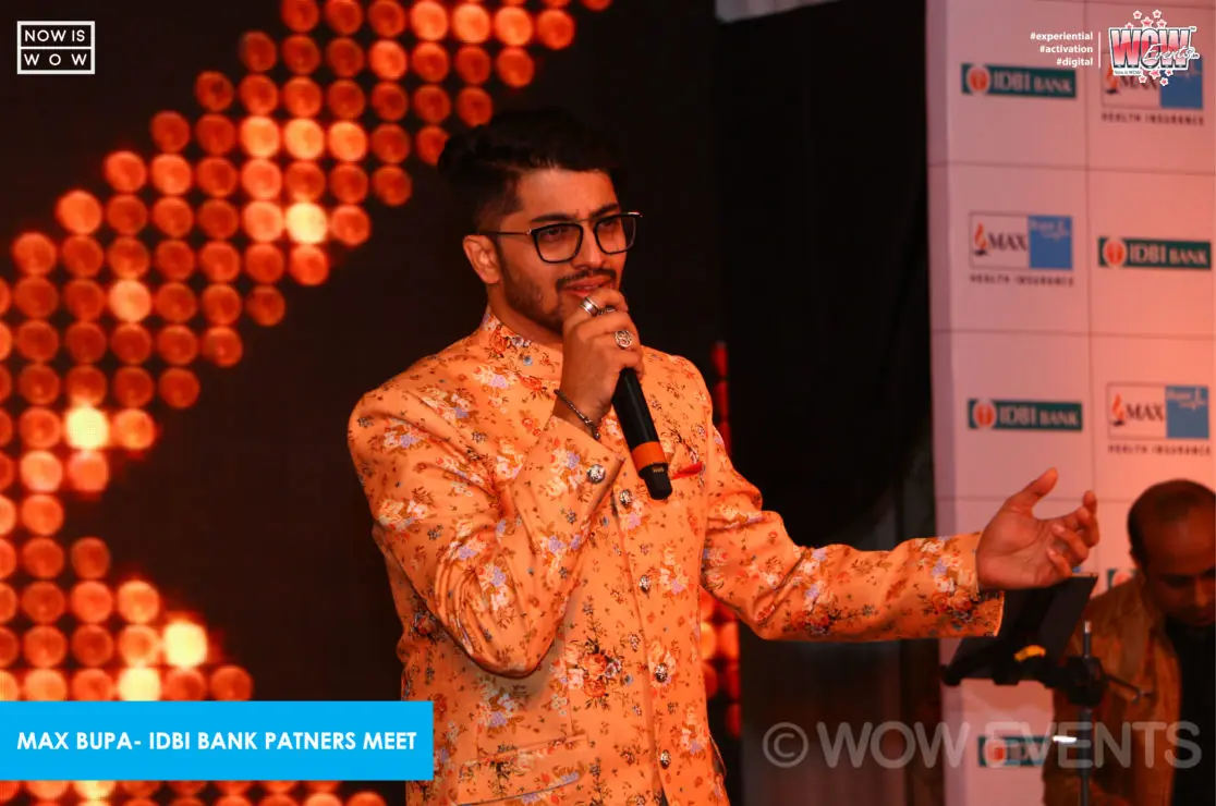 Comedian in a printed jacket performing on stage
