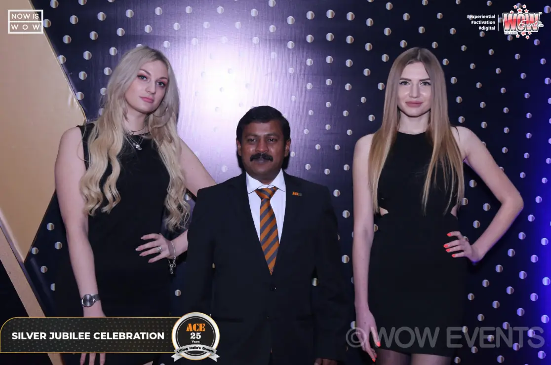 Guest posing with two hostesses at the ACE silver jubilee