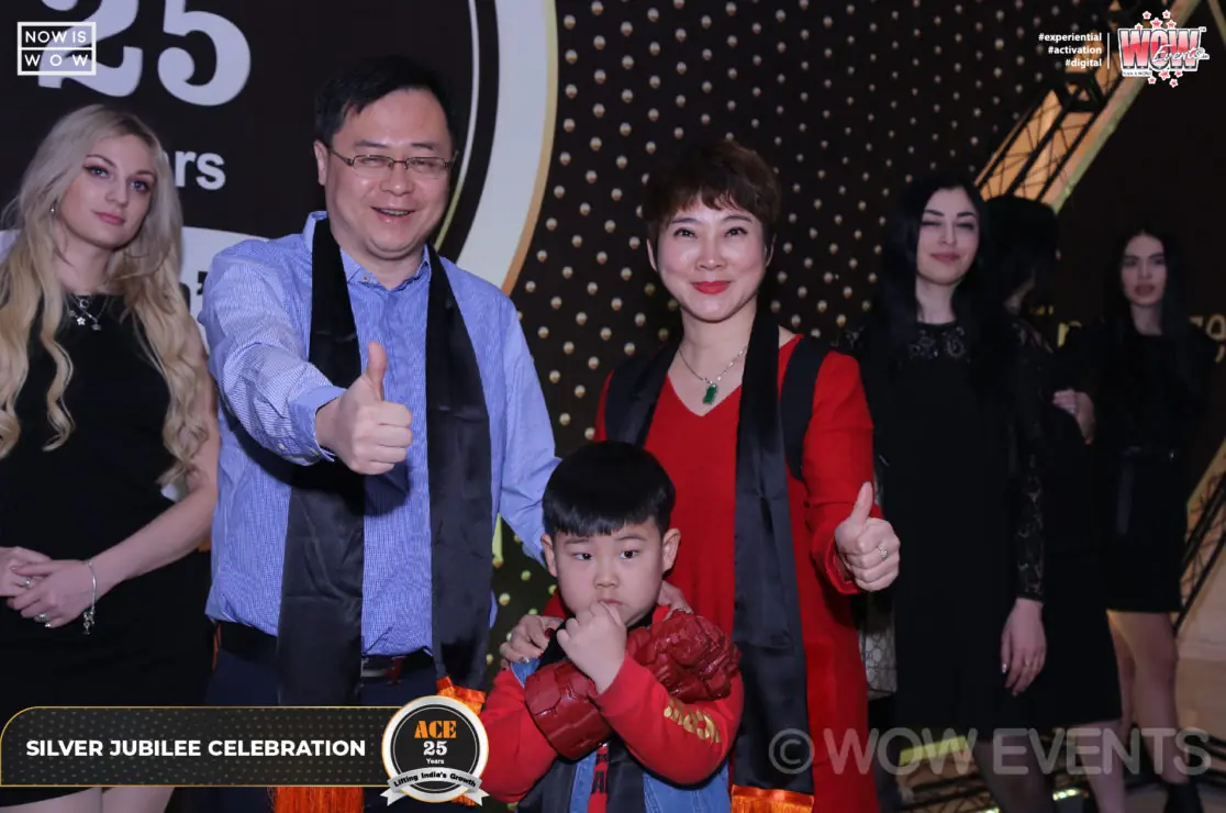 Guests posing at the ACE 25 years photo wall