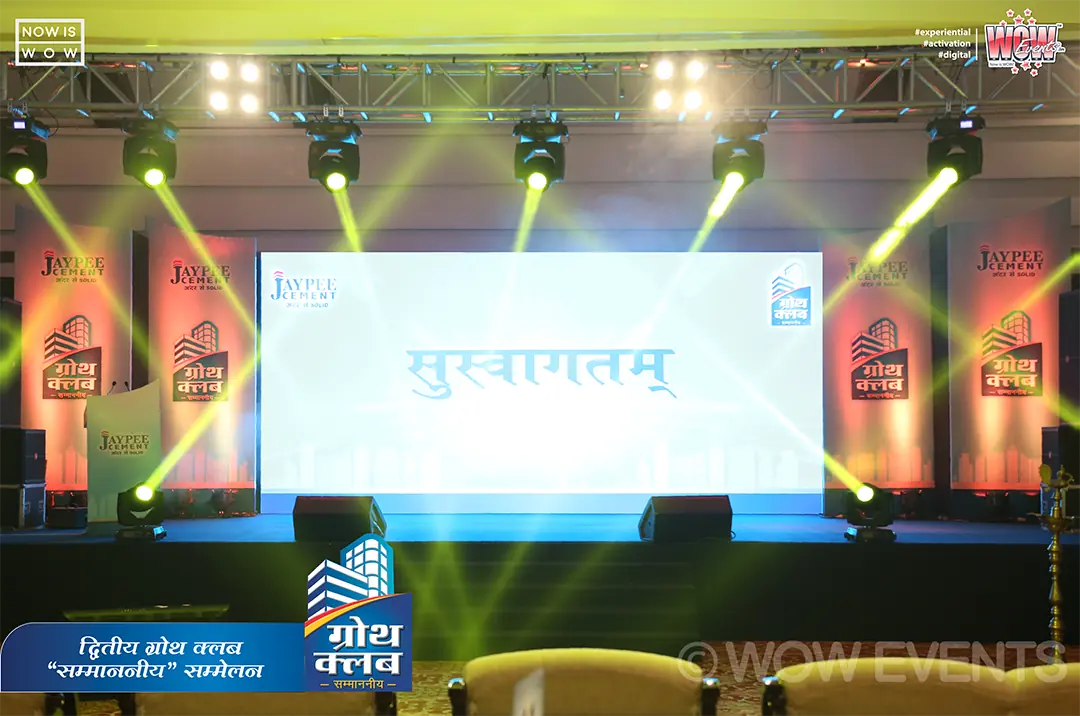 Stage with a Suswagatam welcome screen under coloured lights