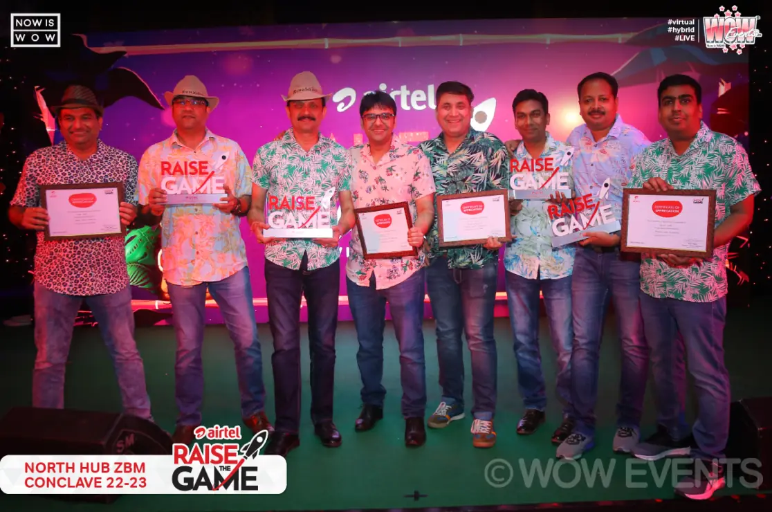 Airtel team holding certificates on stage