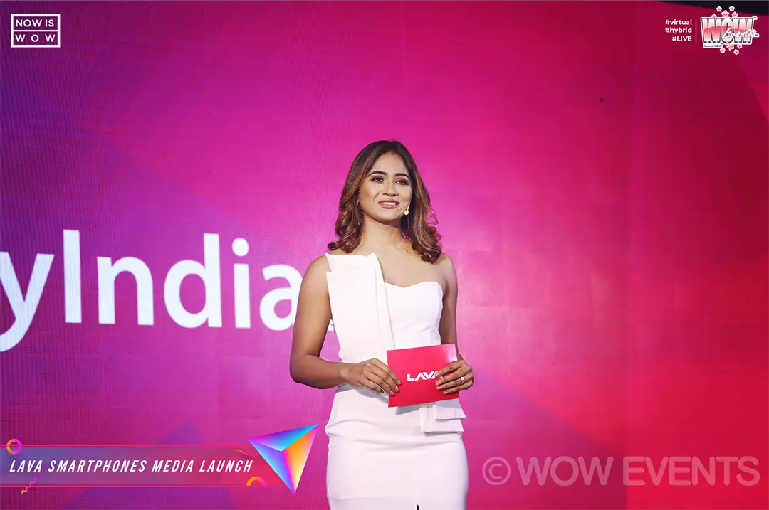 Host in white holding cue cards at the Lava launch
