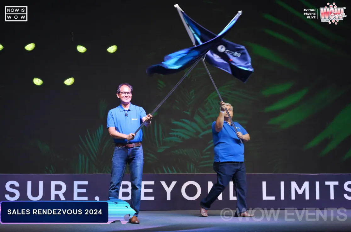 Presenter waving a flag on stage at Naukri ROAR 2024