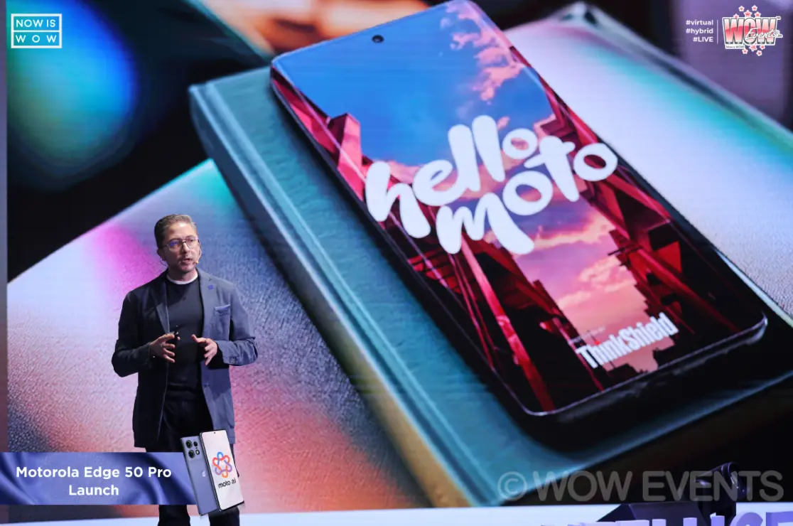 Presenter beside a giant hello moto phone screen