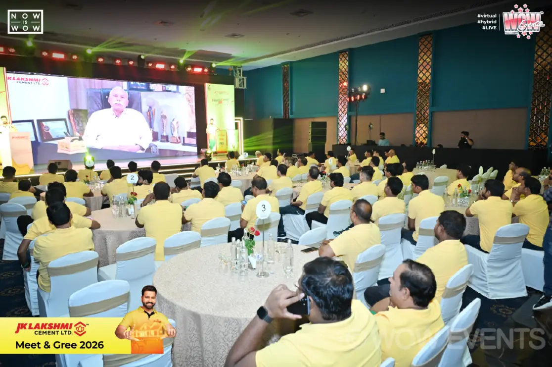 Guests in yellow shirts watching the stage screen in Raipur