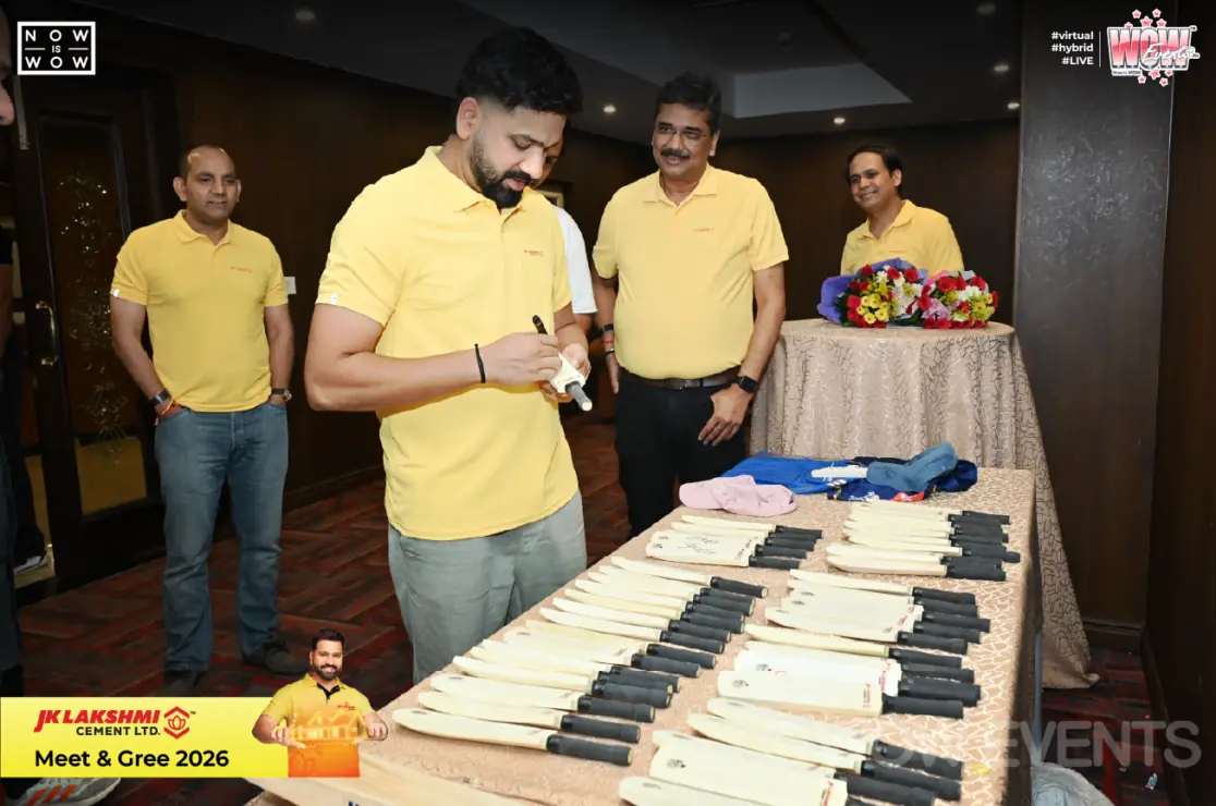 Cricketer signing bats at JK Lakshmi Cement meet and greet